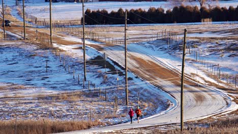 Couple-running-on-a-dirt-road-in-the-countryside