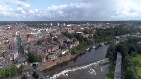 Aerial-track-shot-of-the-River-Dee-above-a-weir-in-Chester,-England