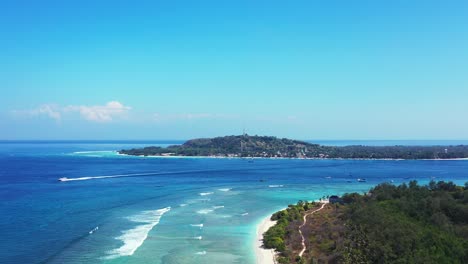 Weiße-Wellen-Schäumen-Auf-Der-Flachen-Türkisfarbenen-Lagune-Rund-Um-Die-Tropische-Insel-Mit-Baumwald-An-Einem-Hellen-Himmel-Bei-Sonnenaufgang-Auf-Bali