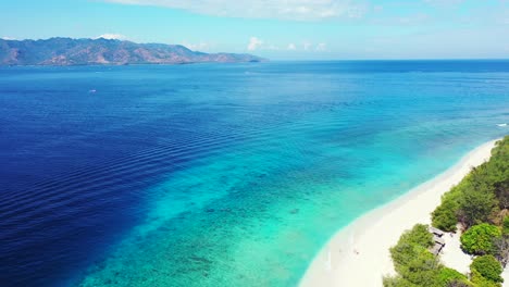 Isla-De-Bali,-Indonesia---Isla-Verde-Y-Exuberante-Rodeada-De-Agua-Oceánica-Azul-Oscuro---Un-Hermoso-Destino-Turístico---Toma-Aérea