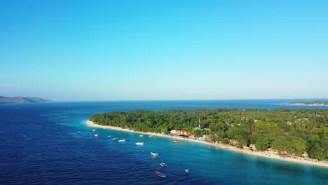 Friedliche-Meereslandschaft-An-Einem-Glänzenden-Tag-über-Dem-Ruhigen-Blauen-Meer-Mit-Vor-Anker-Liegenden-Booten-Nahe-Der-Küste-Einer-Tropischen-Insel-Mit-Weißem-Strand-Und-Grüner-Vegetation-Auf-Bali