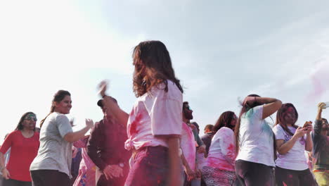 Low-POV-shot-of-young-woman-dancing-with-joy-at-Holi-Festival-of-Color