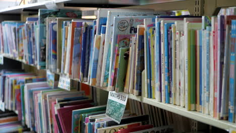 Auf-Regalen-Einer-Grundschule-Gestapelte-Bibliotheksbücher,-Nach-Unten-Geneigt