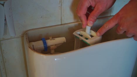 Close-up-footage-of-caucasian-man-repairing-a-toilet-flush-valve
