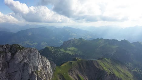 Drohnenaufnahme,-Die-Hinunter-Und-An-Die-Seite-Des-Stockhorns-In-Der-Schweiz-Fliegt,-Mit-Dramatischen-Weißen-Wolken-Und-Sonnenstrahlen,-Die-An-Einem-Heißen,-Sonnigen-Tag-Der-Weiten-Und-Majestätischen-Landschaft-Magie-Und-Farbe-Verleihen