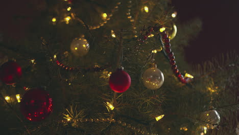 Una-Persona-Cuelga-Una-Bombilla-En-Un-árbol-De-Navidad