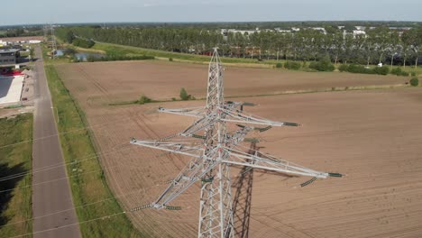 Transmission-tower-and-power-line-energy-supply-in-rural-countryside-setting,-aerial-view