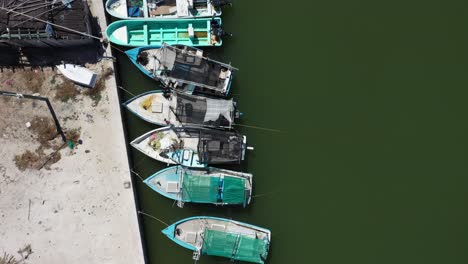 Aerial-view-looking-straight-down-and-camera-showing-small-wooden-fishing-boats-in-a-harbor-in-Mexico