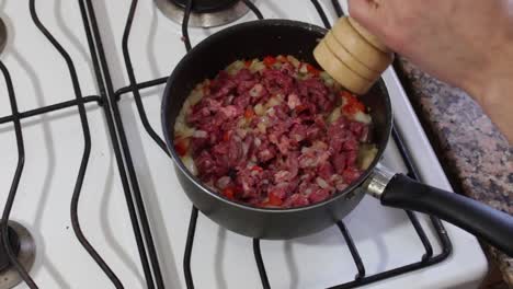 Static-shot-of-hands-seasoning-chopped-meat-with-pepper
