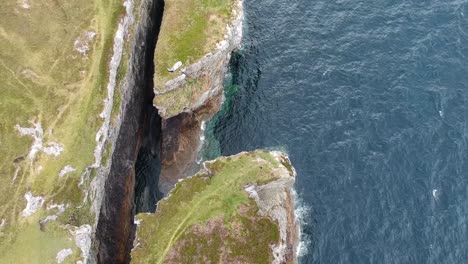 Topdown-panning-drone-shot-of-ocean-cliffs