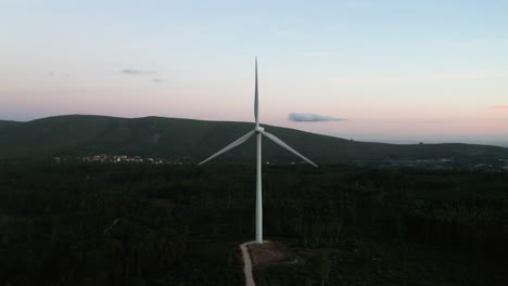 Vista-De-Cerca-De-Las-Turbinas-Eólicas-Giratorias-Contra-El-Cielo-Azul-Durante-La-Puesta-De-Sol-En-Serra-De-Aire-E-Candeeiros,-Leiria-Portugal