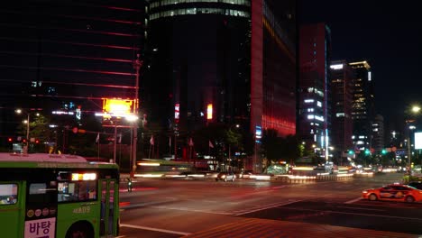 Gangnam-station-crossroad-timelapse,-light-trails-and-night-traffic-of-main-Seoul-street,-pan-left