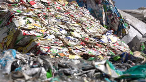 cinematic-shot-of-bales-of-flattened-milk-and-juice-cartons-in-recycling-plant
