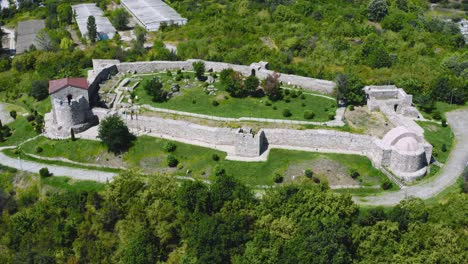 Flying-sideways-over-Peristera-fortress-surrounded-by-green-forest-in-Peshtera-Bulgaria