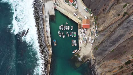 Arrifana-beach-marina-with-sea-wall-barrier,-Aerial-tilt-down-view