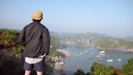 Mann-In-Schwarzer-Jacke-Blickt-Auf-Die-Aussicht-Auf-Das-Ruhige-Meer-Und-Die-Luxusyacht-Auf-Der-Insel-Cat-Ba-In-Vietnam-–-Luftaufnahme