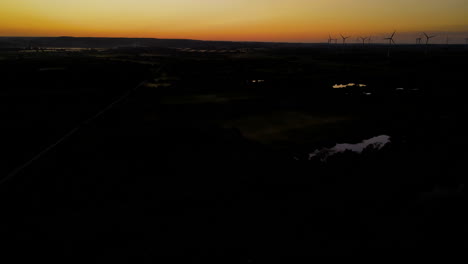 Luftaufnahme---Langsames-Wegfliegen-Vom-Windpark-Bei-Sonnenuntergang,-Windkraftanlagen-Silhouette-Auf-Orangefarbenem-Himmelshintergrund,-Puck,-Pomorskie,-Polen