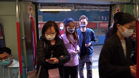 Crowd-of-Asian-Chinese-people-wearing-face-mask-walk-into-MTR-train-in-Hong-Kong
