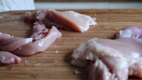 Cutting-Chicken-Breast-Meat-In-Wooden-Chopping-Board-Using-Kitchen-Knife