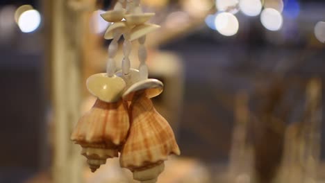 Shell-accessories-hanging-at-market-stall,-rotating-slow-motion-shot