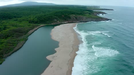 Amazing-aerial-view-of-Veleka-beach-with-strong-waves-and-calm-river-during-a-cloudy-day