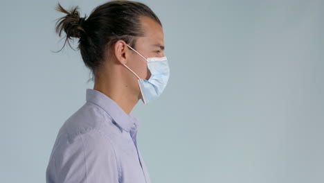 Right-side-shot-of-man-putting-on-hygienic-mask