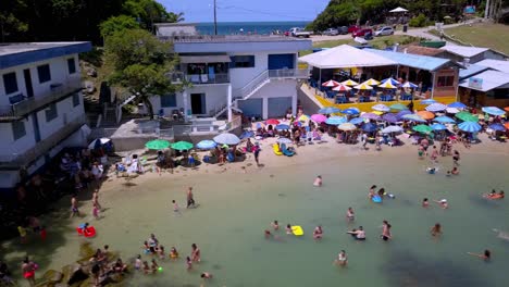 Aerial-dolly-right-shot-revealing-the-Praia-da-Sepultura-crowded-with-people-in-Bombinhas