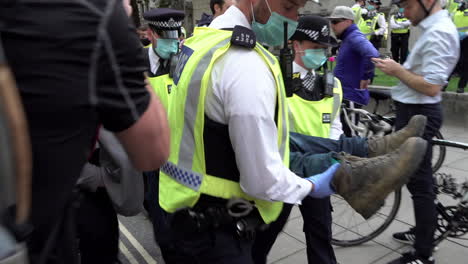 London-Metropolitan-officers-carry-detained-Extinction-Rebellion-climate-change-protestors-though-police-cordon-lines-during-protests-outside-parliament-in-Westminster-during-the-Coronavirus-pandemic