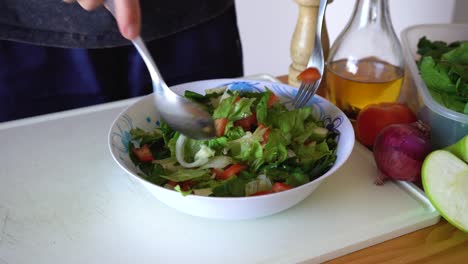 Man-Mixing-Salad-With-Dressing-Using-Spoon-And-Fork