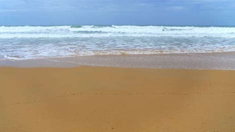 Landscapes-view-of-waves-breaking-on-beach-sand-and-the-sky-on-a-stormy-rainy-season