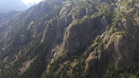 Oszillierende-Luftaufnahme-Eines-Wunderschönen-Wasserfalls,-Der-Von-Einem-Großen-Berg-In-Frankreich-Herabfließt