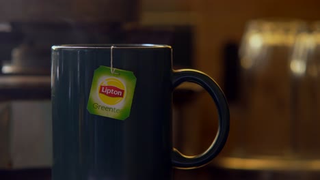 Lipton-green-tea-bag-in-cup-of-hot-water-steam-coming-from