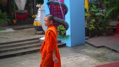 Ein-Novizenjunge,-Der-Auf-Dem-Gelände-Des-Drachentempels-Sam-Phran-In-Thailand-Spaziert