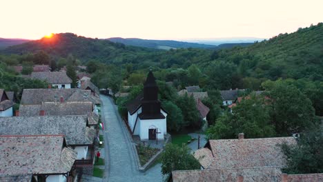 Drohne-Fliegt-Im-Sonnenuntergang-über-Die-Historischen-Straßen-Von-Holloko,-Ungarn
