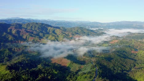 Luftaufnahme-Mit-Drohne-über-Den-Wunderschönen-Bunten-Bergen-Von-Constanza,-Dominikanische-Republik,-Blendende-Wolken-Und-Nebel-An-Einem-Klaren-Und-Kalten-Morgen