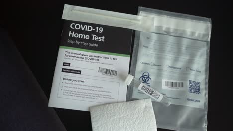 Covid-19-Coronavirus-home-test-kit-with-guide,-test-tube-and-cotton-q-tip-on-the-table