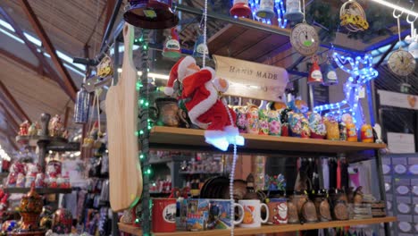 Santa-Claus-miniature-toy-is-climbing-on-rope,-on-Christmas-market-stall
