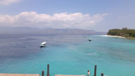 Adisn-woman-running-on-wooden-jetty-of-Gili-Meno-pier-during-sunshine-with-epic-landscape