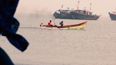 Zwei-Indische-Fischer-Segeln-Während-Des-Sonnenuntergangs-In-Einem-Kleinen-Hölzernen-Motorboot-Mitten-Im-Meer-Und-Genießen-Den-Abend-In-Einem-Kleinen-Boot.-Videohintergrund-In-Full-HD-In-Filmen