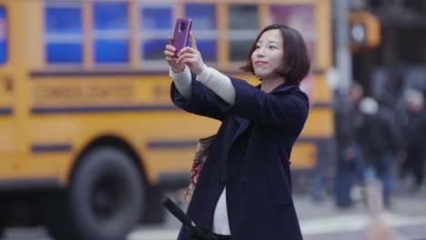 Una-Mujer-Asiática-Posando-Para-Una-Serie-De-Selfies-En-Times-Square,-Ciudad-De-Nueva-York