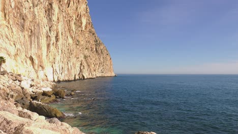 Sea-cliffs-of-headland-and-wide-blue-sea,-calpe,-spain