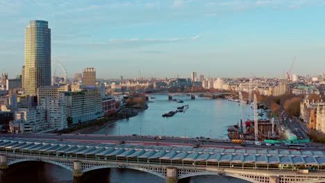 Filmische-Drohnenaufnahme-Aus-Der-Luft-Von-Der-Blackfriars-Bridge-In-Richtung-London-Eye-Und-Den-Häusern-Des-Londoner-Parlaments