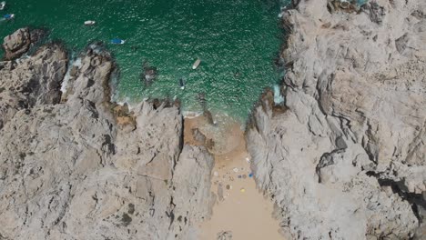Aerial-View-of-Beach-Between-Rock-Formations
