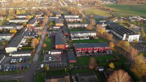 Aerial-flyover-neighbourhood-suburb-in-Sweden,-drone-flying-forward-at-sunset