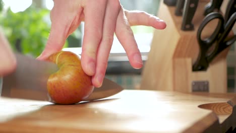 Zeitlupenaufnahme-Eines-Apfels,-Der-Mit-Einem-Scharfen-Messer-In-Zwei-Hälften-Geschnitten-Wird