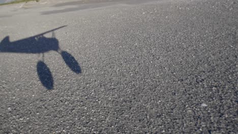 Shadow-of-Small-Civil-Airplane-Taking-Off-on-Rural-Runway,-Passenger-POV