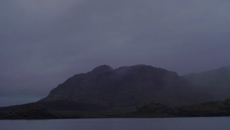 dramatic-iceland-landscape-at-night,-mountain-lake,-camera-pan-from-left-to-right