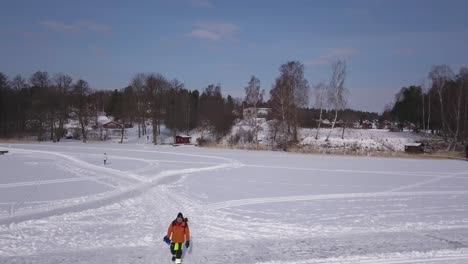 Smooth-tracking-shot-of-eager-fisherman-walking-over-groomed-pathway-frequented-by-cross-country-skiers
