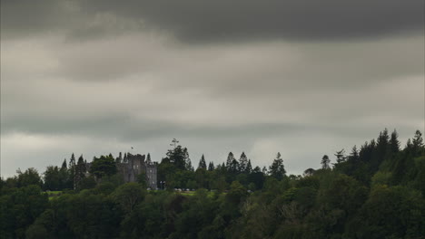 Time-lapse-of-historical-castle-surrounded-by-forest-on-a-cloudy-day-in-Ireland