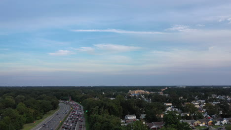 An-aerial-view-next-to-a-busy-parkway-in-the-evening,-during-rush-hour